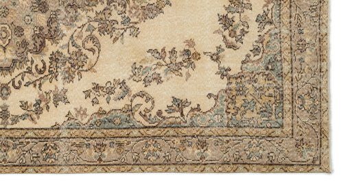Load image 1 in gallery view. Beige traditional rug with a distressed floral medallion pattern in muted brown, blue, and cream tones.