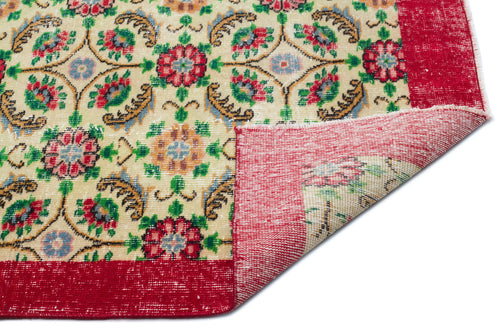 Load image 1 in gallery view. Cream rug with a multi-colored floral medallion pattern and a wide red border, shown with a corner folded over.