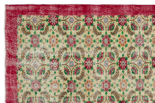 Load image 1 in gallery view. Distressed beige rug with a red border and a repeating floral medallion pattern in red, green, and blue.