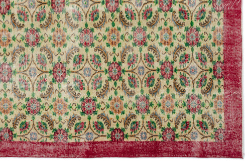 Load image 1 in gallery view. Beige rug with a repeating floral medallion pattern in red, green, and gold, featuring a solid red border.