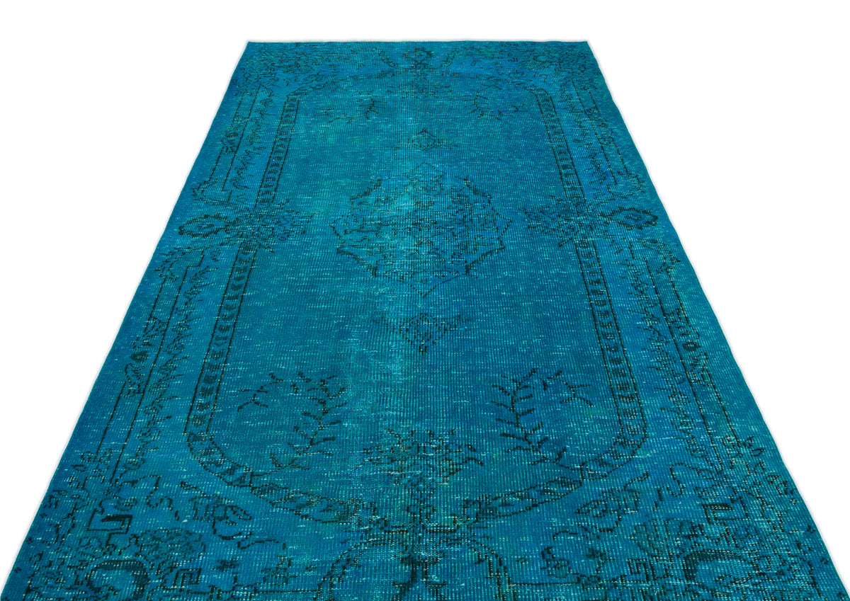 Teal distressed vintage-style rug with a dark blue central medallion and ornate border pattern on a white background.