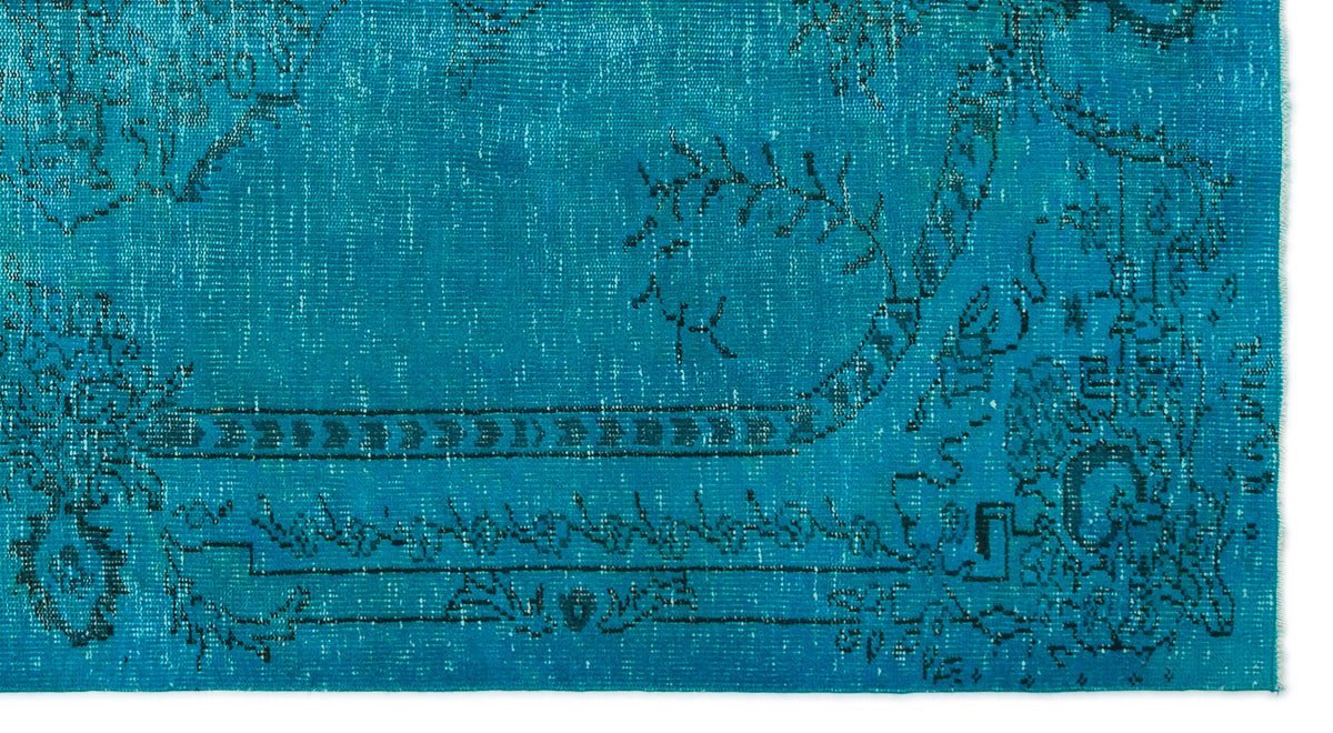 Teal rug with a distressed black traditional floral and geometric border pattern on a white background.