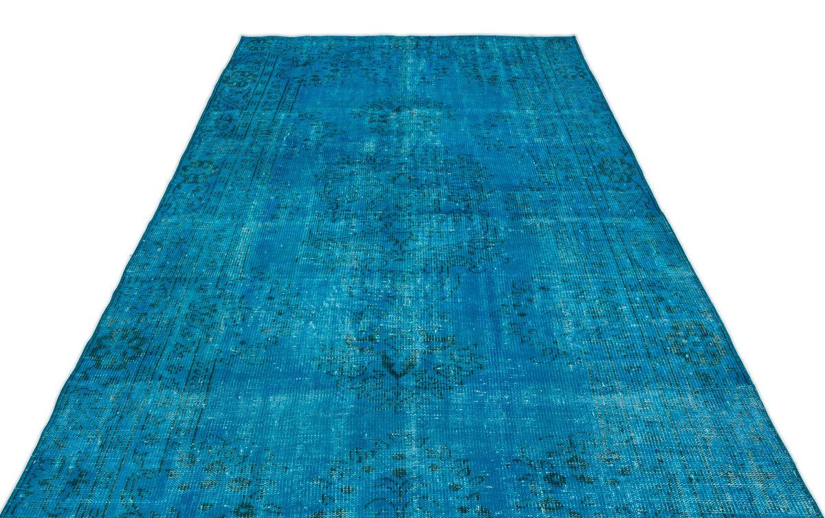 Bright blue distressed area rug with a faded traditional medallion pattern on a white background.