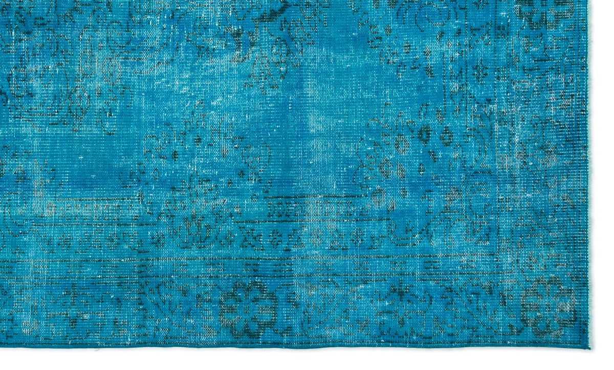 Bright turquoise rug with a distressed, faded traditional floral medallion pattern and a decorative border.
