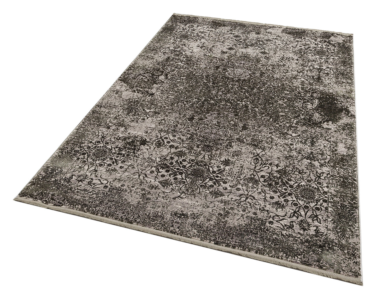 Charcoal and grey distressed rug with a faded traditional floral medallion pattern on a white background.