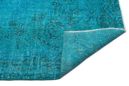 Load image 1 in gallery view. Teal distressed rug with a faded traditional floral pattern and a folded corner showing the woven backing.