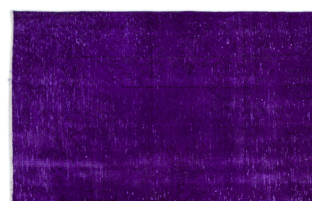 Deep purple vintage-style rug with a distressed, faded texture and subtle, worn-away traditional patterns.