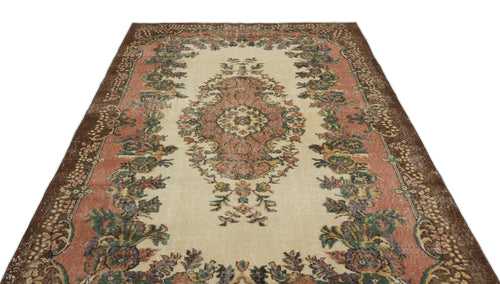 Load image 1 in gallery view. Vintage-style rug with a cream center, floral medallion, and wide brown border featuring muted pink and green accents.