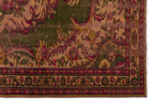 Load image 1 in gallery view. Distressed traditional rug with a dark green, tan, and red floral pattern and a geometric border.