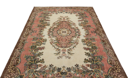 Load image 1 in gallery view. Cream, pink, and brown vintage-style rug with a central floral medallion and ornate border pattern.