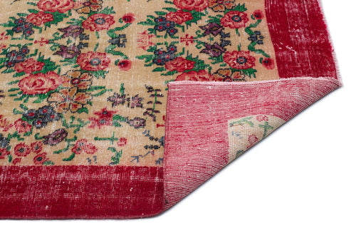 Load image 1 in gallery view. Beige rug with red floral pattern and wide red border, shown with a corner folded over to reveal the underside.