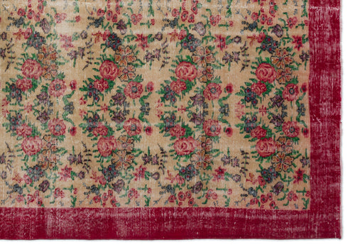 Load image 1 in gallery view. Beige vintage-style rug with a distressed floral pattern in red, green, and dark blue, featuring a solid red border.