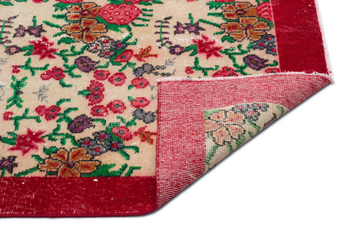 Load image 1 in gallery view. Beige rug with a red border and multi-colored floral pattern, shown with a corner folded over on a white background.