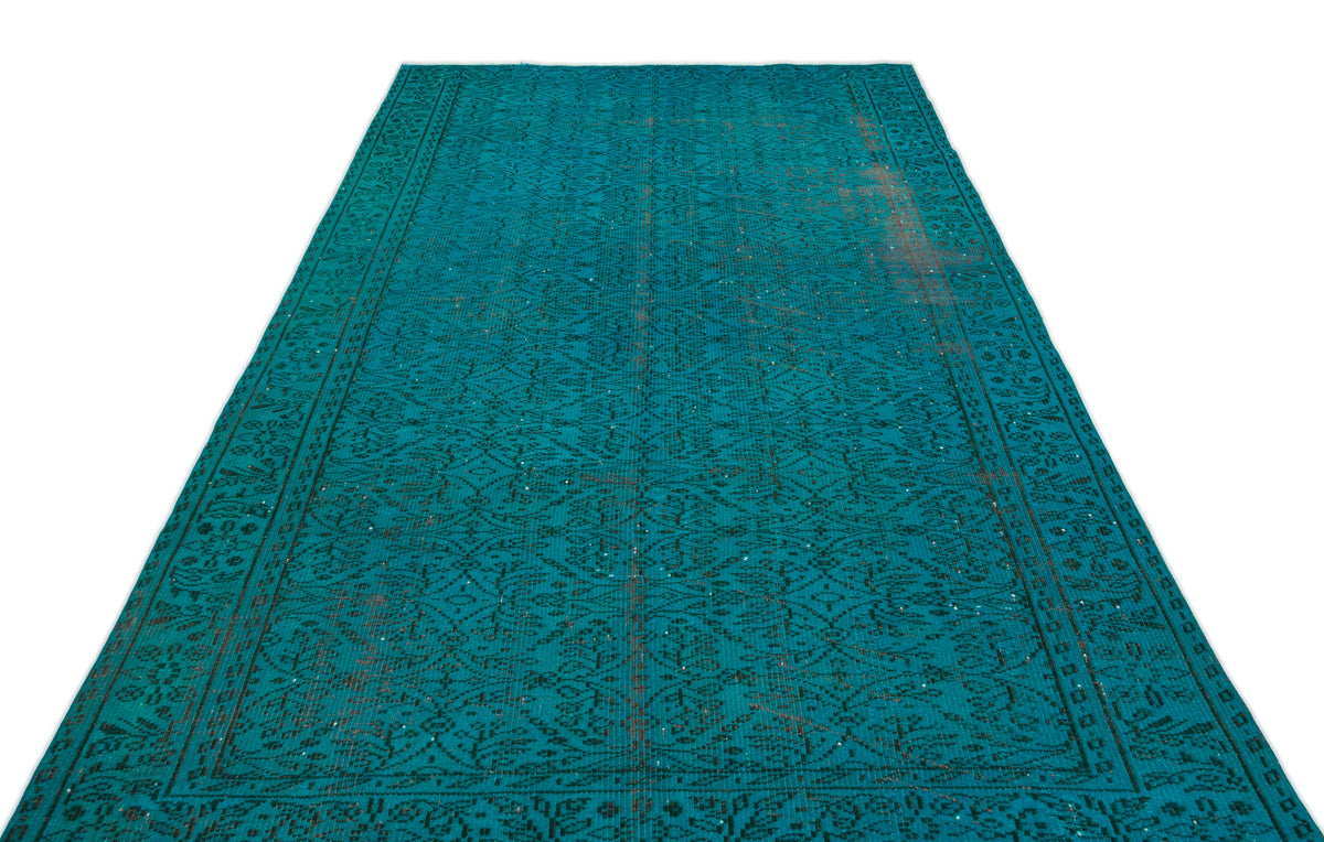 Teal vintage-style rug with a dark, intricate floral medallion pattern and distressed brown accents on a white background.