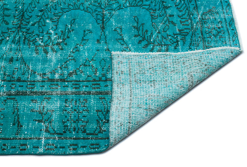 Load image 1 in gallery view. Teal distressed rug with a dark floral medallion pattern, showing a folded corner revealing the lighter underside.