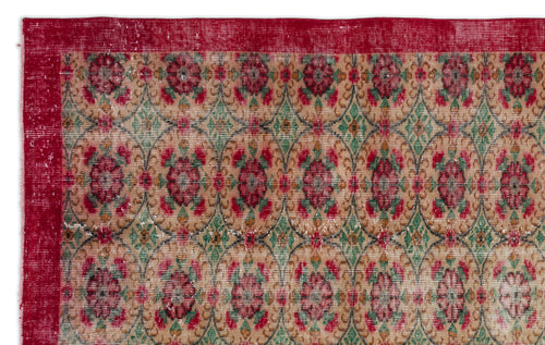 Load image 1 in gallery view. Distressed tan rug with a red border and a repeating pattern of red floral medallions and green geometric diamonds.