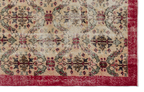 Load image 1 in gallery view. Beige vintage-style rug with a distressed floral medallion pattern in red, green, and black, featuring a solid red border.