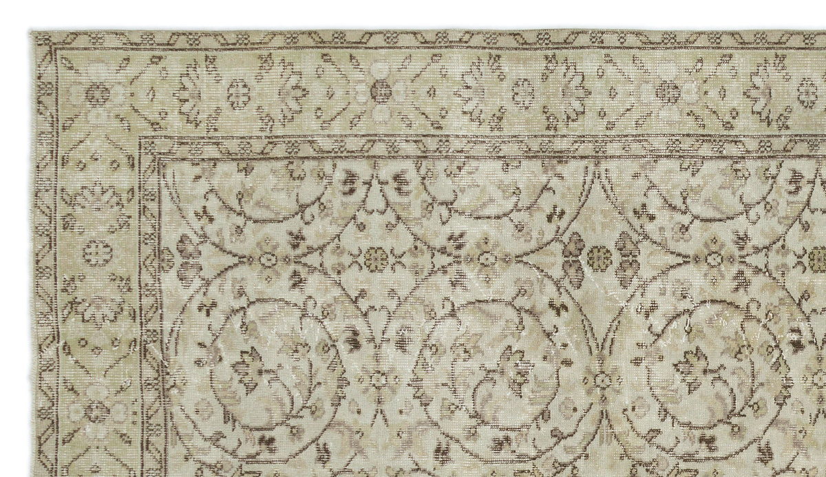 Beige and taupe traditional rug with a distressed floral vine pattern and a decorative border.