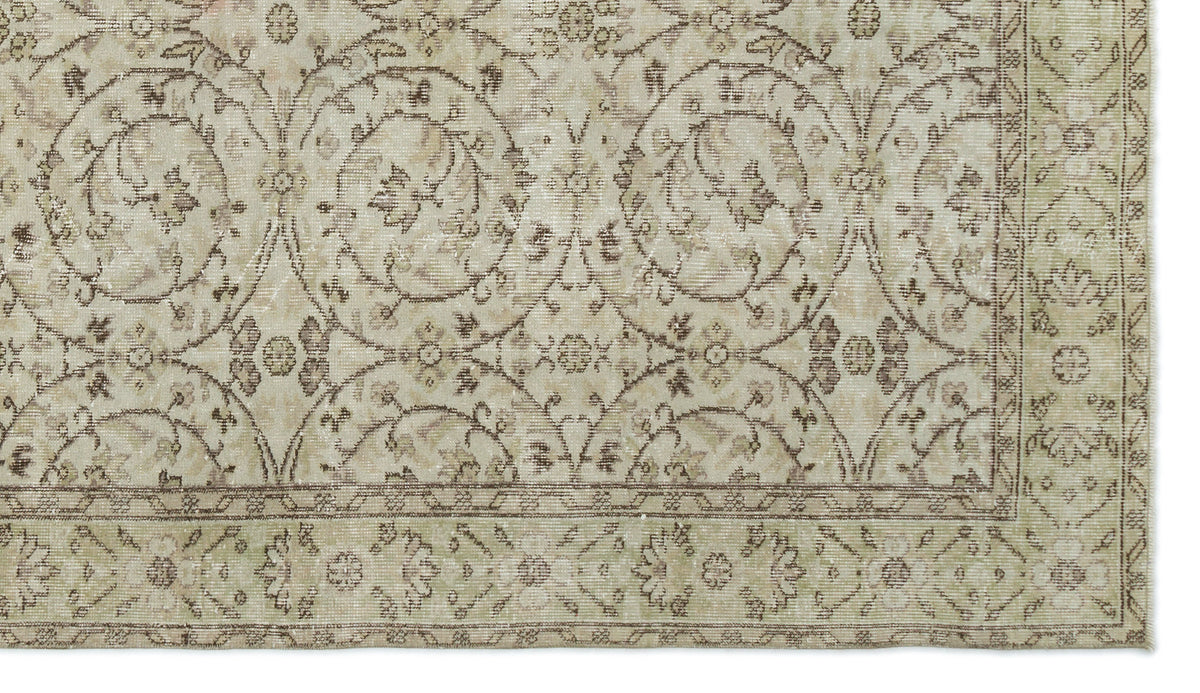 Beige and taupe vintage-style rug with a distressed floral medallion pattern and a decorative border.