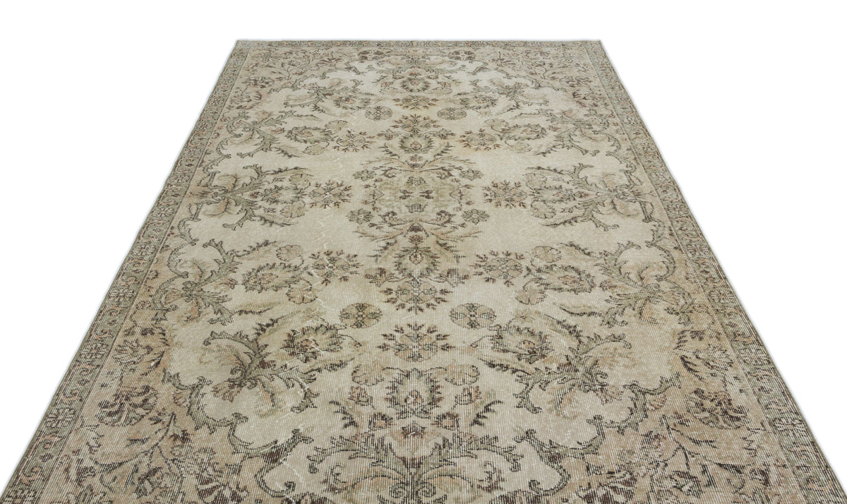 Beige and taupe vintage-style rug with a faded floral medallion pattern on a white background.