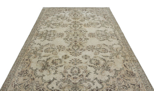 Load image 1 in gallery view. Beige and taupe vintage-style rug with a faded floral medallion pattern on a white background.