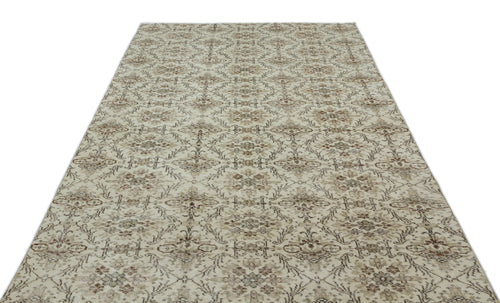 Load image 1 in gallery view. Beige and brown vintage-style rug with a repeating floral medallion pattern on a white background.