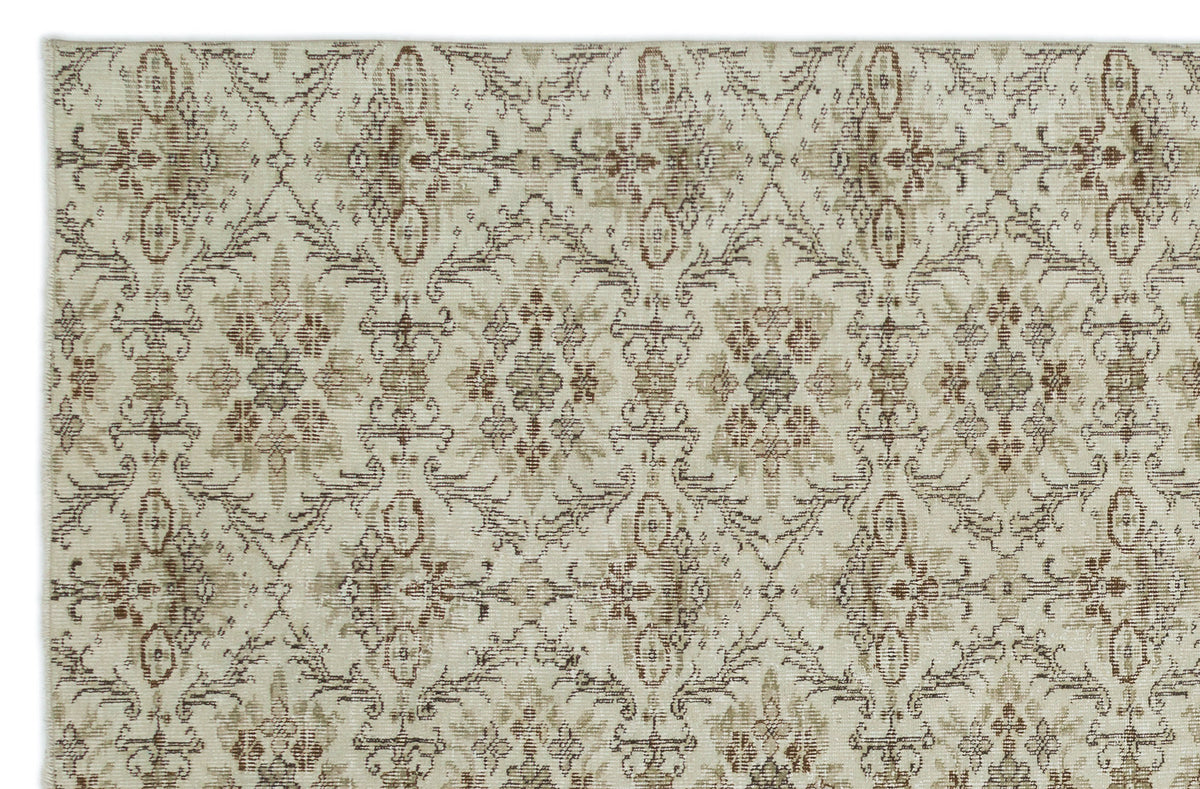 Beige and brown rug with a repeating distressed floral medallion pattern on a white background.