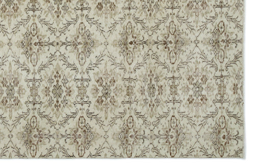Load image 1 in gallery view. Beige and brown rug with a distressed, repeating floral medallion pattern on a cream background.
