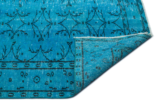 Load image 1 in gallery view. Bright turquoise distressed rug with a black geometric pattern and a folded corner showing the underside.