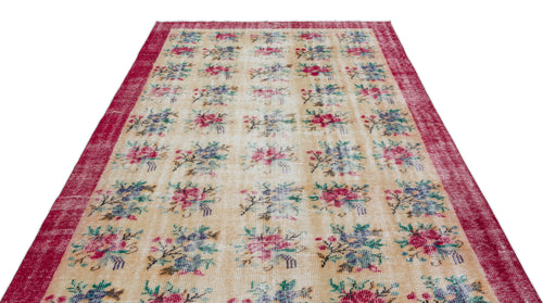 Load image 1 in gallery view. Beige rug with a repeating floral grid pattern in pink, blue, and green, framed by a wide, distressed red border.
