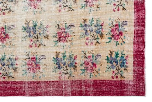 Load image 1 in gallery view. Beige rug with a repeating floral bouquet pattern in pink, blue, and green, framed by a distressed red border.