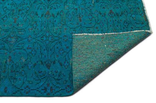 Load image 1 in gallery view. Teal rug with a dark blue floral medallion pattern, shown with a corner folded to reveal the textured backing.