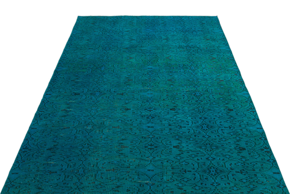 Teal vintage-style rug with a dark, distressed traditional medallion pattern on a white background.