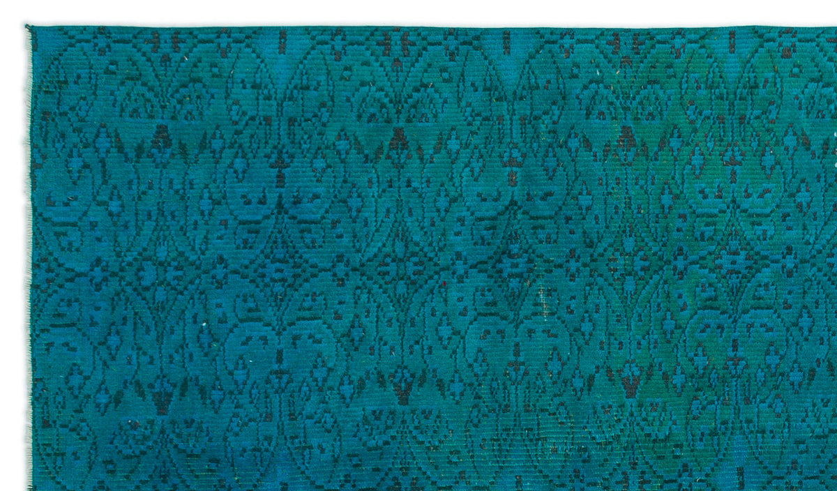 Teal and black flatweave rug featuring a repeating intricate damask-inspired geometric pattern.