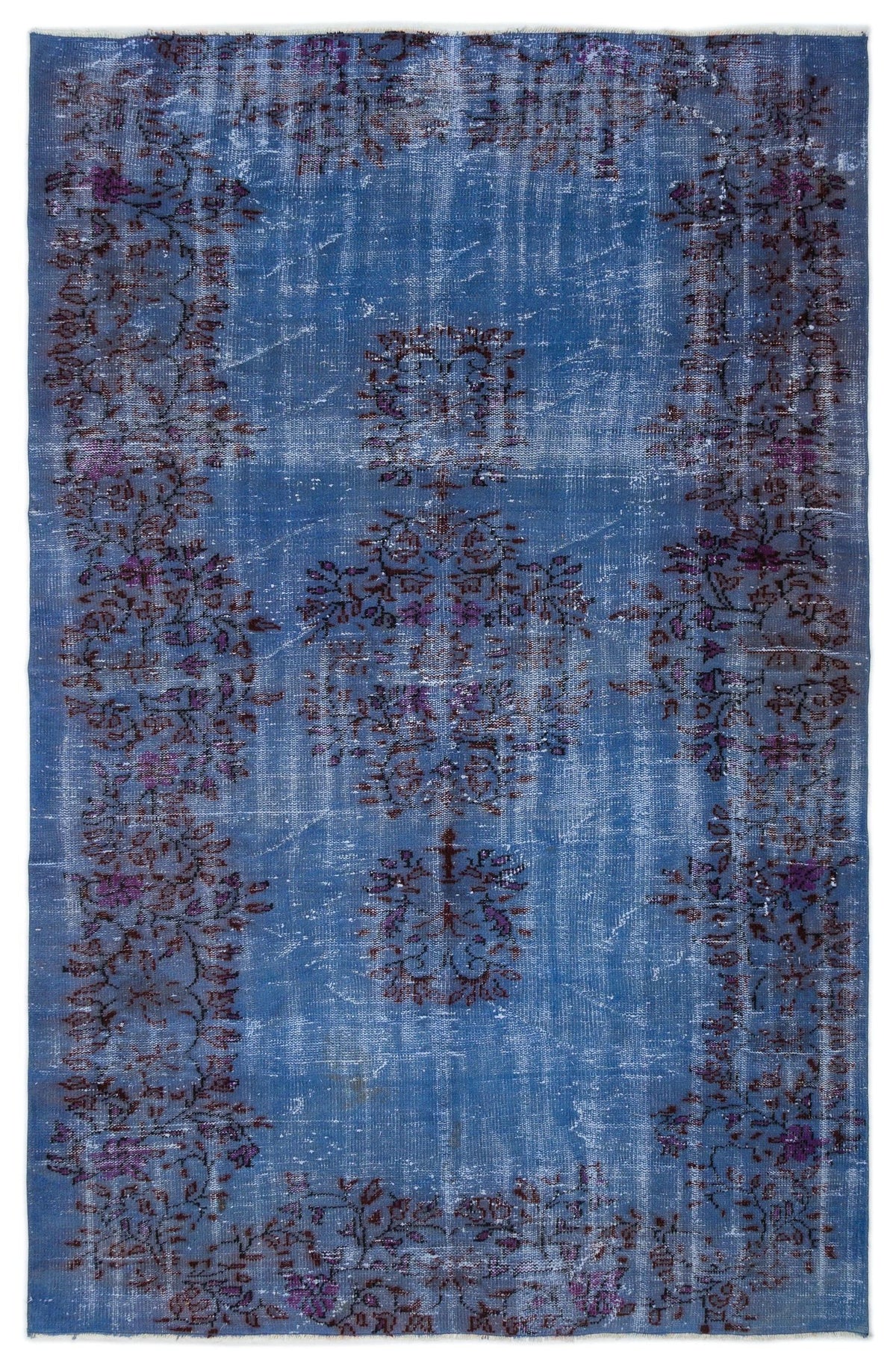 Distressed blue rug with a faded purple floral medallion and border pattern on a white background.