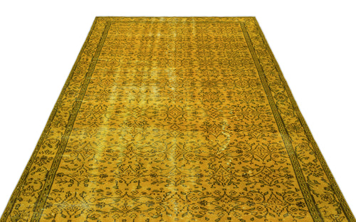 Load image 1 in gallery view. Mustard yellow vintage-style rug with a distressed floral pattern and a dark border on a white background.