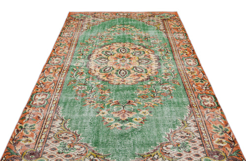 Load image 1 in gallery view. Green and orange vintage-style rug with a central floral medallion and ornate border pattern on a white background.