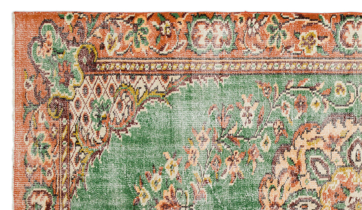 Distressed green and orange rug with a traditional floral medallion pattern and ornate border.