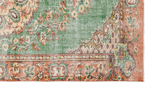 Load image 1 in gallery view. Distressed green and terracotta rug with a traditional floral medallion pattern and a decorative border.