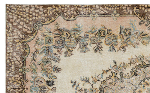 Load image 1 in gallery view. Distressed vintage-style rug with a brown border and floral medallion pattern in muted pink, blue, and cream.