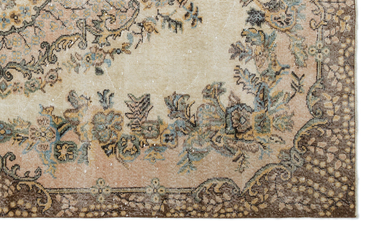 Distressed beige and peach rug with a floral medallion pattern and dark brown border.