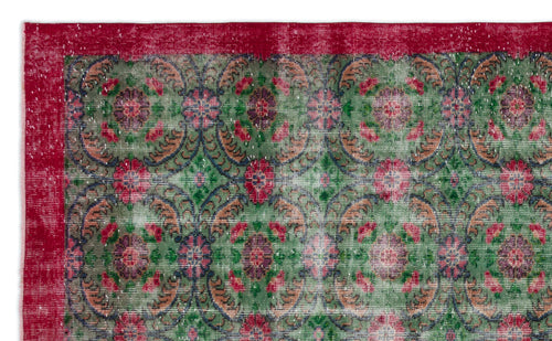 Load image 1 in gallery view. Distressed green rug with a repeating floral medallion pattern and a solid red border.