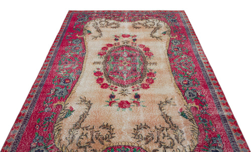 Load image 1 in gallery view. Distressed vintage-style rug with a central floral medallion, cream field, and wide magenta border on a white background.