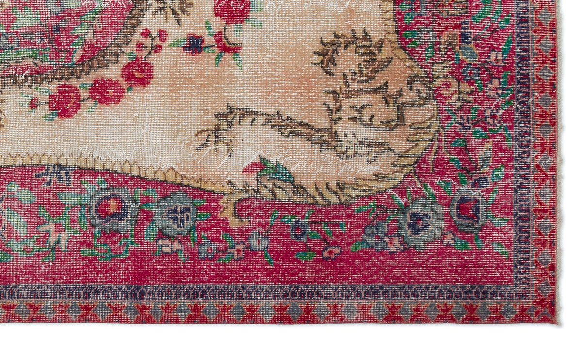 Distressed vintage-style rug with a beige center, red floral border, and intricate botanical motifs.