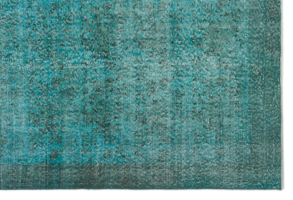 Teal distressed overdyed rug with a faded traditional pattern and a solid border.