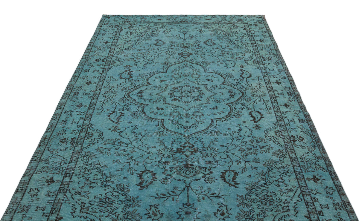 Turquoise and charcoal distressed rug with a traditional central medallion and floral border pattern.