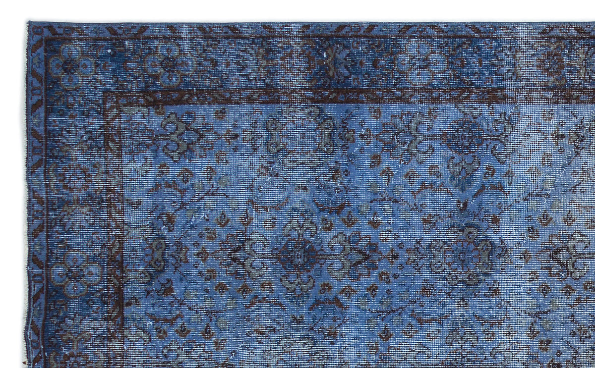 Blue and dark brown distressed traditional rug with a faded floral medallion pattern and a bordered edge.