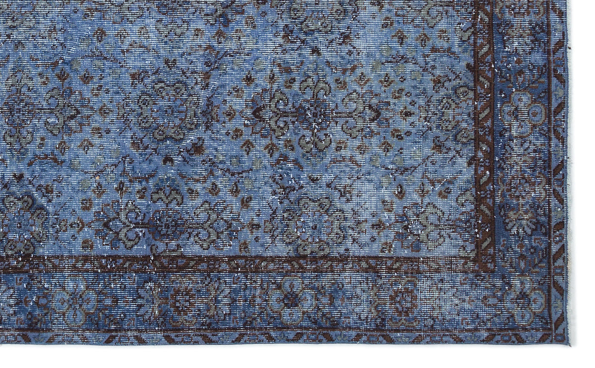 Blue and brown distressed traditional rug with a floral medallion pattern and a detailed border.