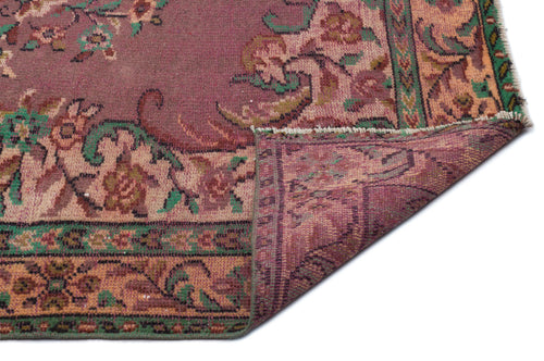Load image 1 in gallery view. Distressed plum, green, and tan floral patterned rug with a folded corner showing the reverse side.