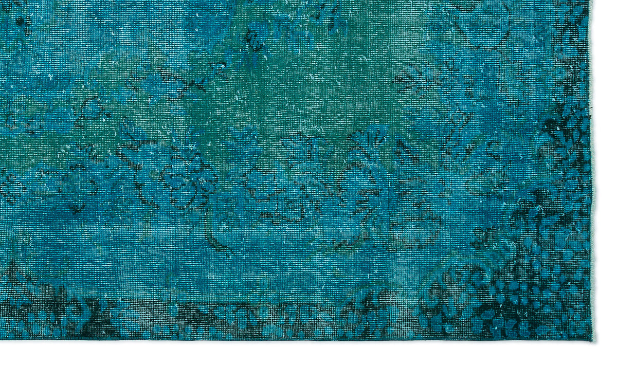 Teal and navy blue distressed rug with a faded traditional floral medallion pattern.